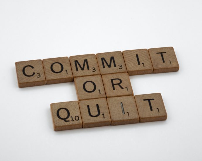 scrabble tiles that spell out commit or quit